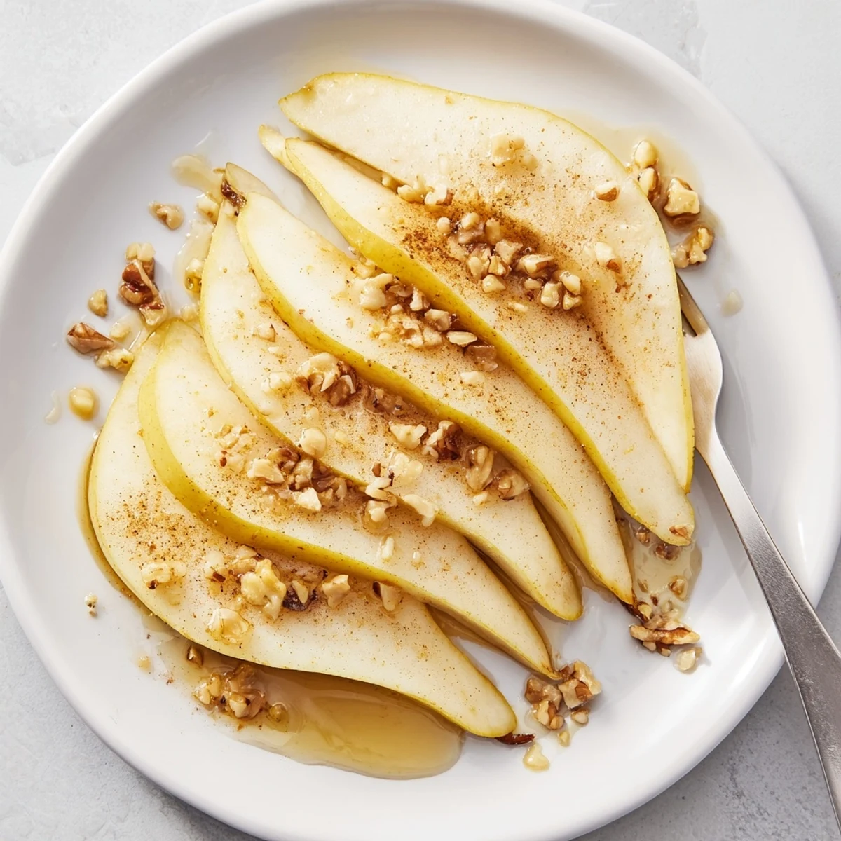 Freshly sliced pear with honey drizzle, a simple yet elegant snack or dessert.