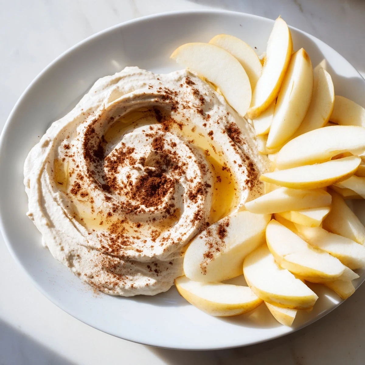 Crisp, juicy apple slices ready for dipping in a smooth peanut butter dip, a quick snack.