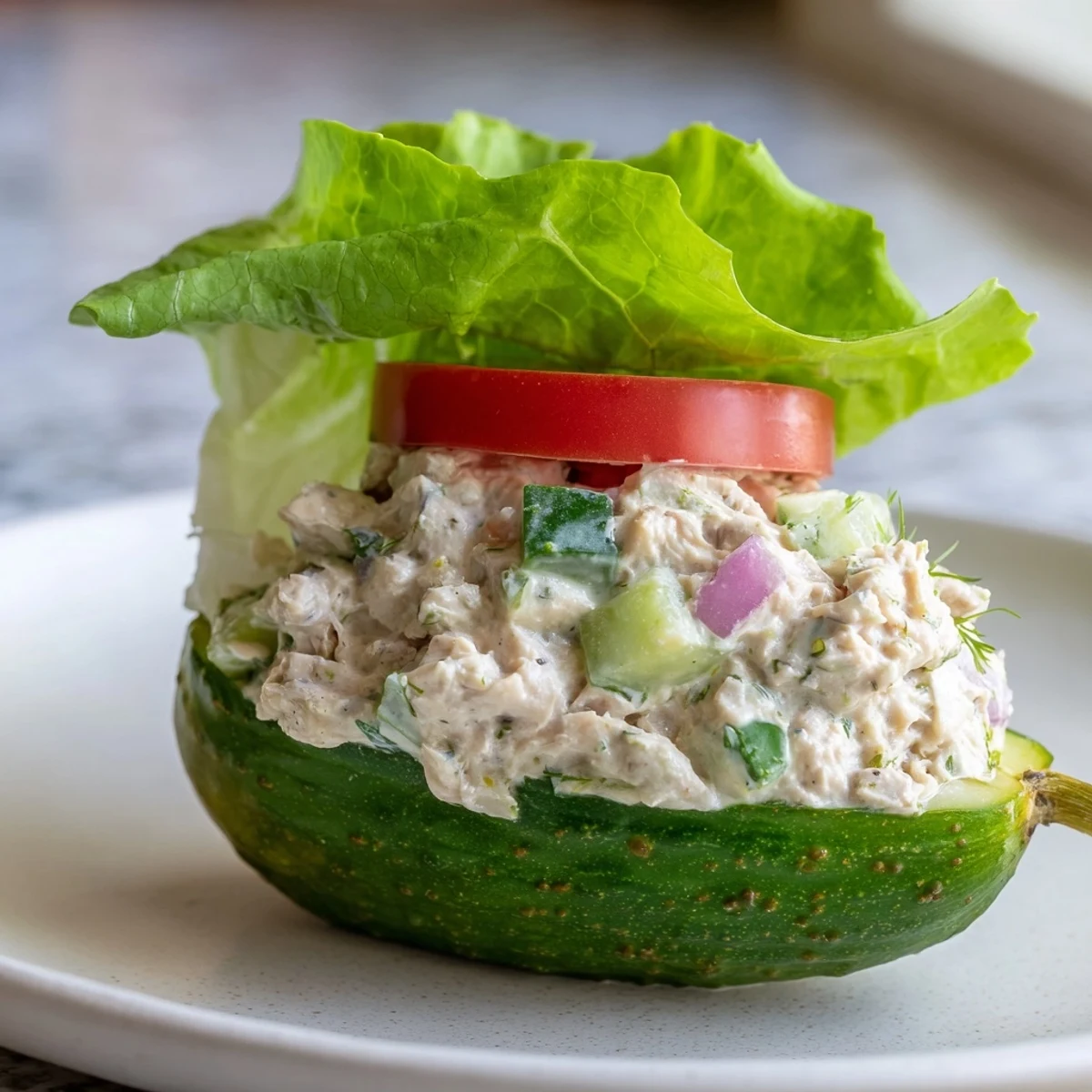 Chicken salad brimming from a sliced pickle, a refreshing low-carb Pickle Sandwich ready to eat.