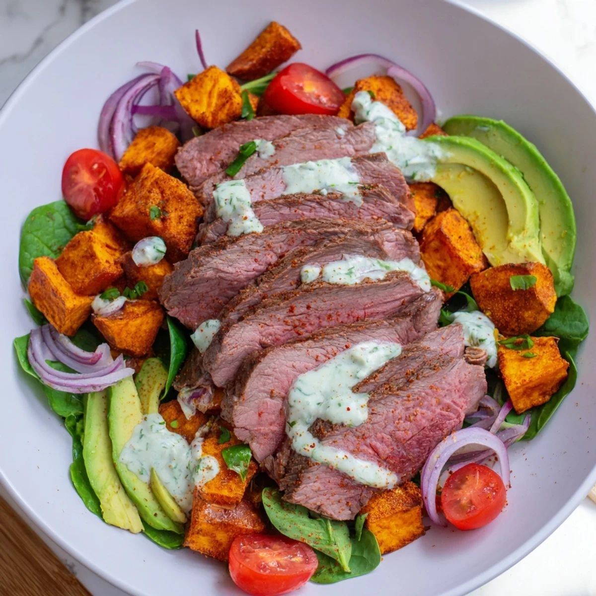A delicious and healthy Beef Avocado Sweet Potato Bowl, the image shows a beautifully plated meal.