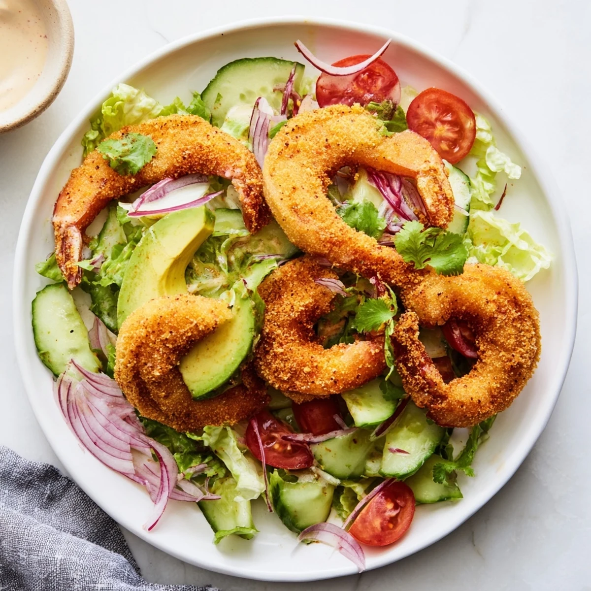 Fresh, vibrant Spicy Crispy Shrimp Salad with creamy avocado and zesty sriracha-lime dressing, a delicious meal.