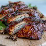 Tender slices of Five-Spice Roast Ducks on a plate alongside fluffy jasmine rice and vibrant stir-fried greens.