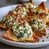 Savory Mediterranean Spinach and Feta Cheese Crisps garnished with herbs and sesame seeds on a rustic serving platter.