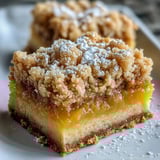 Golden-baked Homemade Lemon Crumb Bars, cut into squares and lightly dusted with powdered sugar.