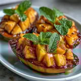 Vibrant tropical fruit platter with ripe mango and pineapple slices, garnished with mint and lime for a refreshing party display.
