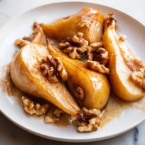 Golden-brown Maple-Warm Cozy Plate: Caramelized Pear and Walnut Bake, a comforting dessert with a hint of spice.