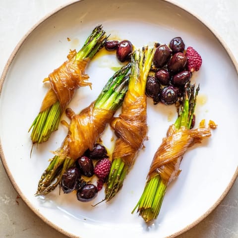 A beautiful plated Botanical Lattice, featuring colorful fruit nestled in a fresh asparagus grid.