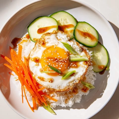This delicious Egg Rice Bowl presents crunchy rice and a runny yolk, with fresh vegetables and toppings.