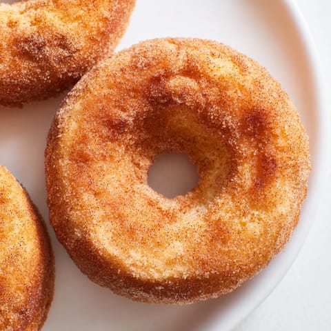 Golden Air Fryer Cinnamon Sugar Donuts, warm and fluffy, served alongside a steaming mug of coffee.