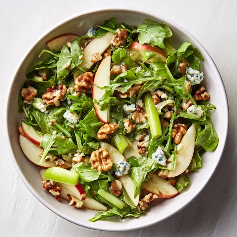 Colorful bowl of Apple and Walnut Salad featuring crisp apple slices, crunchy walnuts, and a drizzle of sweet-tart dressing.