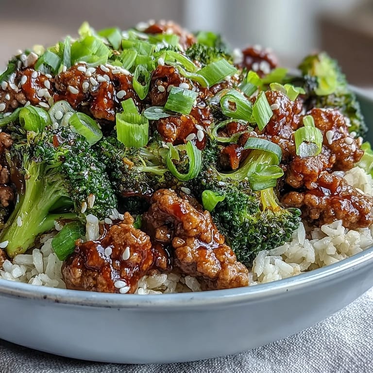 Garnished Sweet and Spicy Turkey Broccoli Bowls ready to serve, with sriracha-honey glaze and chopsticks beside the steaming bowl.