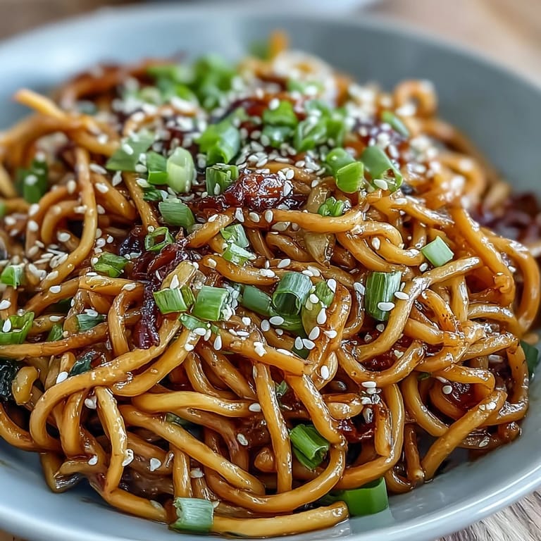 Savory Asian Ginger Scallion Noodles with Soy Glaze: al dente noodles tossed with aromatic ginger, scallions, and a rich soy glaze, topped with toasted sesame seeds for added crunch.