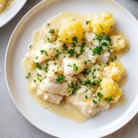 Creamy Icelandic Fish Stew, filled with tender fish, is served hot with fresh green herbs.