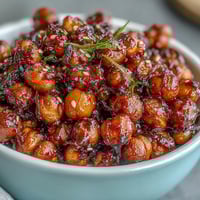 Crispy chickpeas in spicy chili-garlic sauce served over fluffy jasmine rice in a vibrant vegan bowl.  